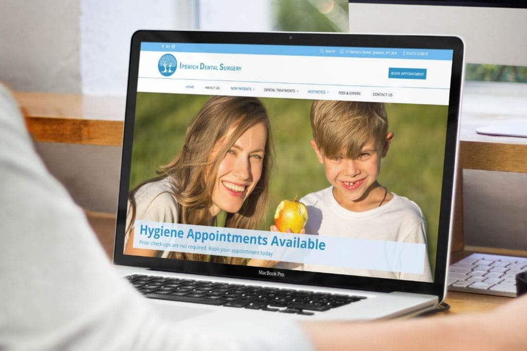 A woman is sitting at a desk with a laptop computer.