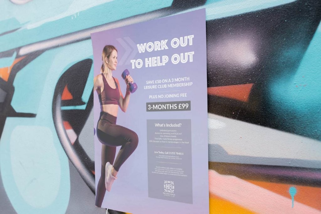 A poster that says work out to help out is on a wall.